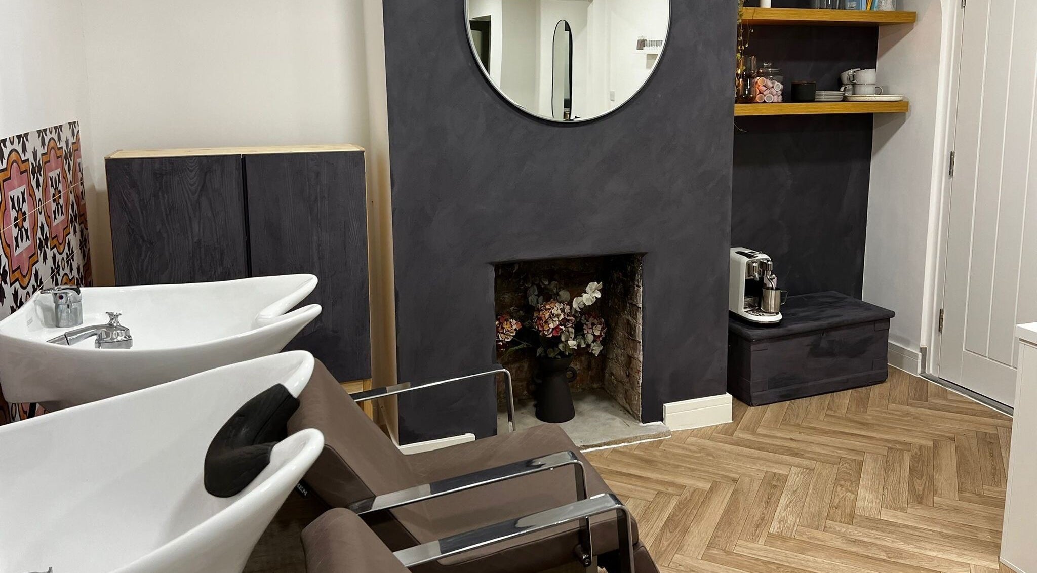 Chic salon interior at Luxury Locks, Oakley, England, GB, featuring sleek wash stations and modern decor.