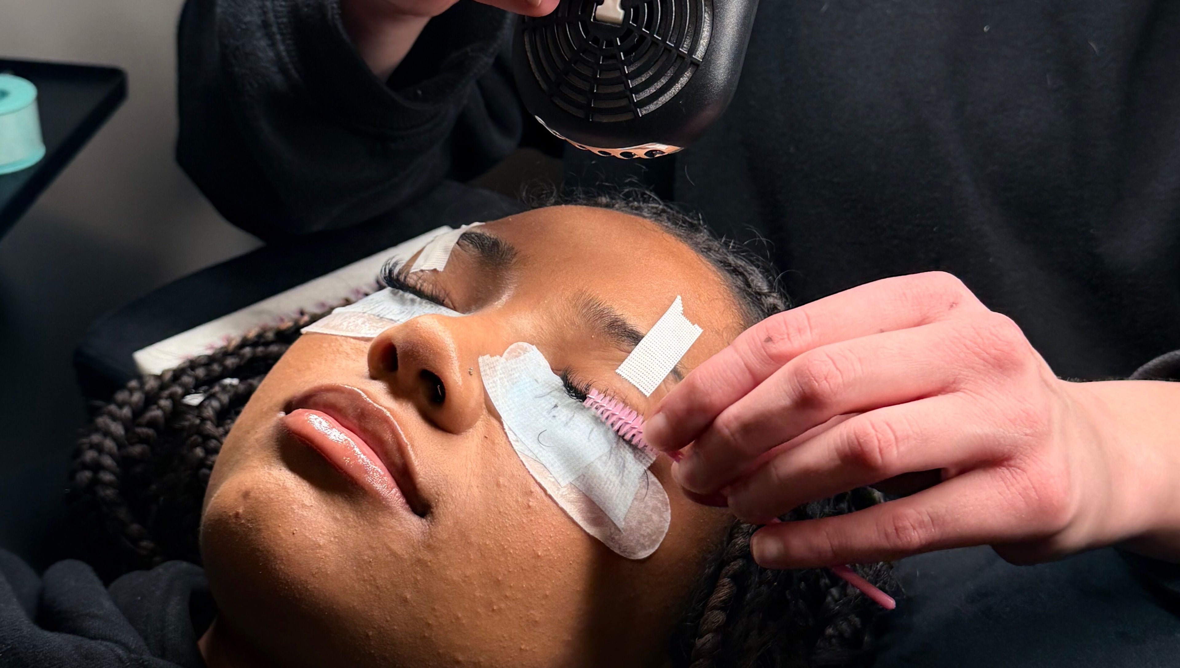 Client receiving a lash extension treatment at Majasbeautyco in Hamilton, Ontario, CA for voluminous lashes.