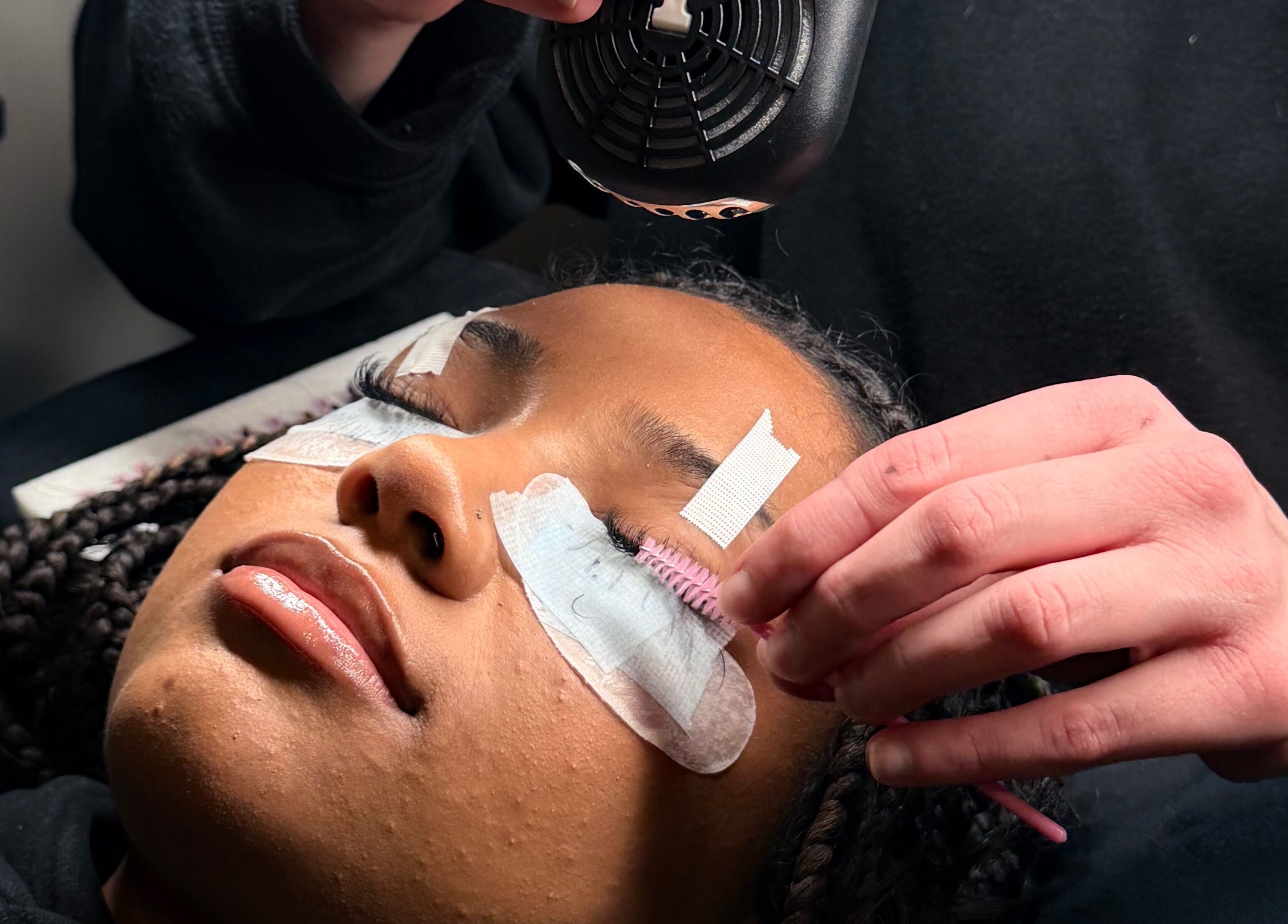 Client receiving a lash extension treatment at Majasbeautyco in Hamilton, Ontario, CA for voluminous lashes.