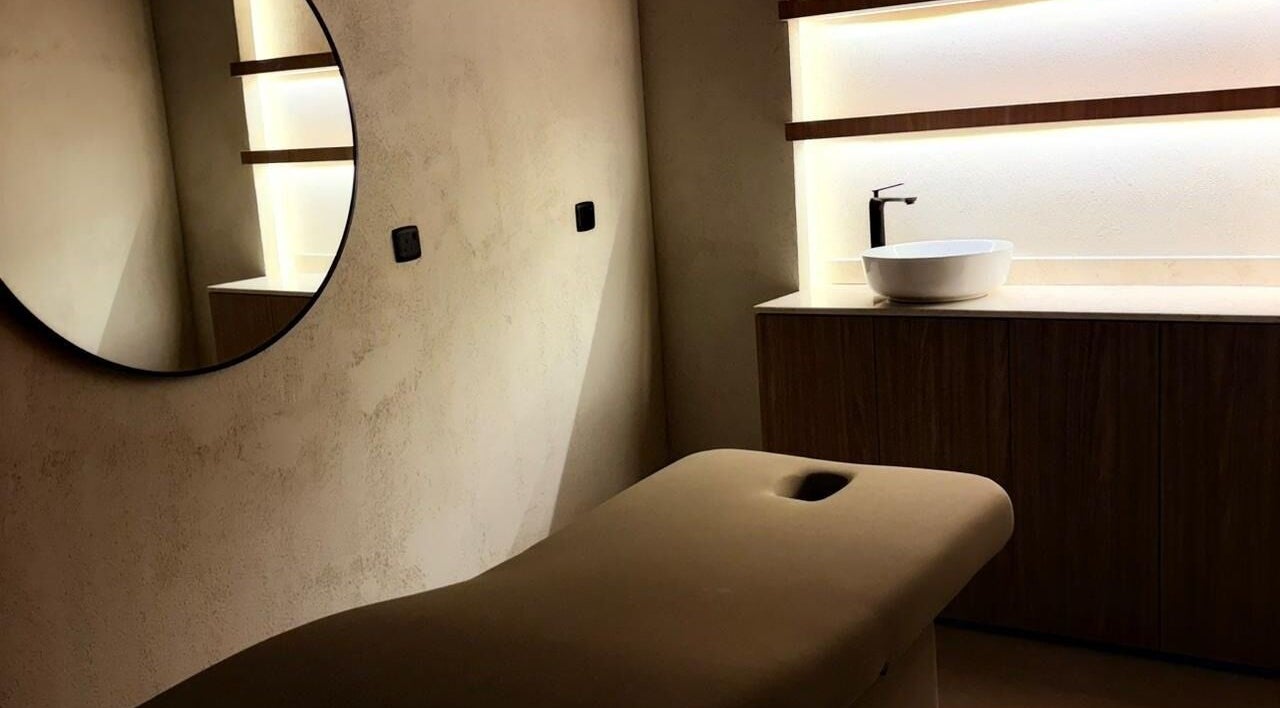 غرفة هادئة للعناية في She & Her Salon بالرياض، SA، مع ديكور أنيق ومغسلة بيضاء.