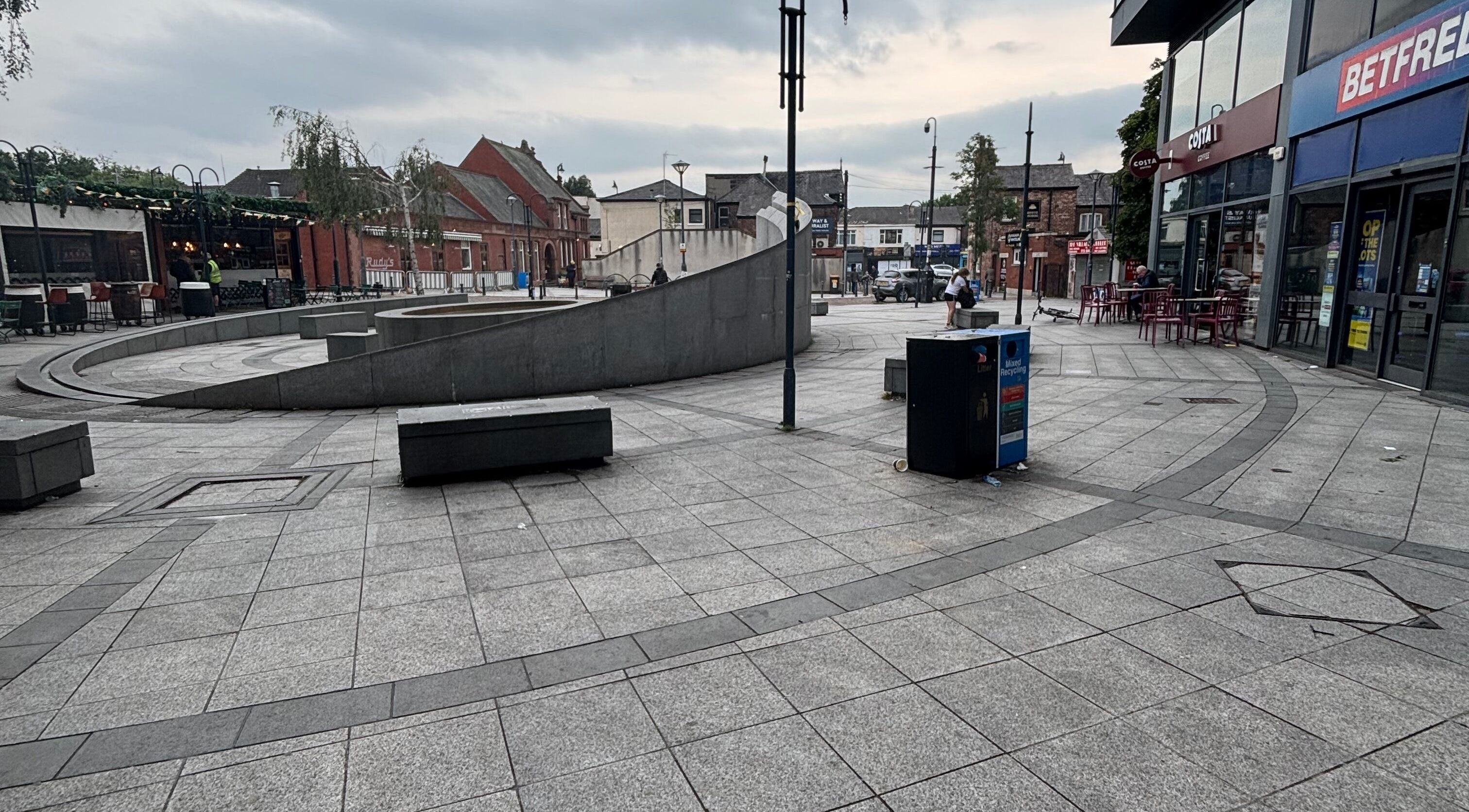 View of bustling square near Ej beauty service in Prestwich, England, GB with modern architecture.