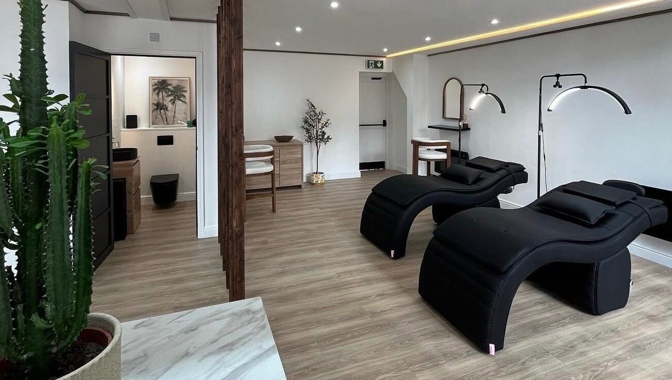 Modern wellness interior at Signature Brows CO, Flint, Wales, GB featuring sleek black loungers and minimalist decor.