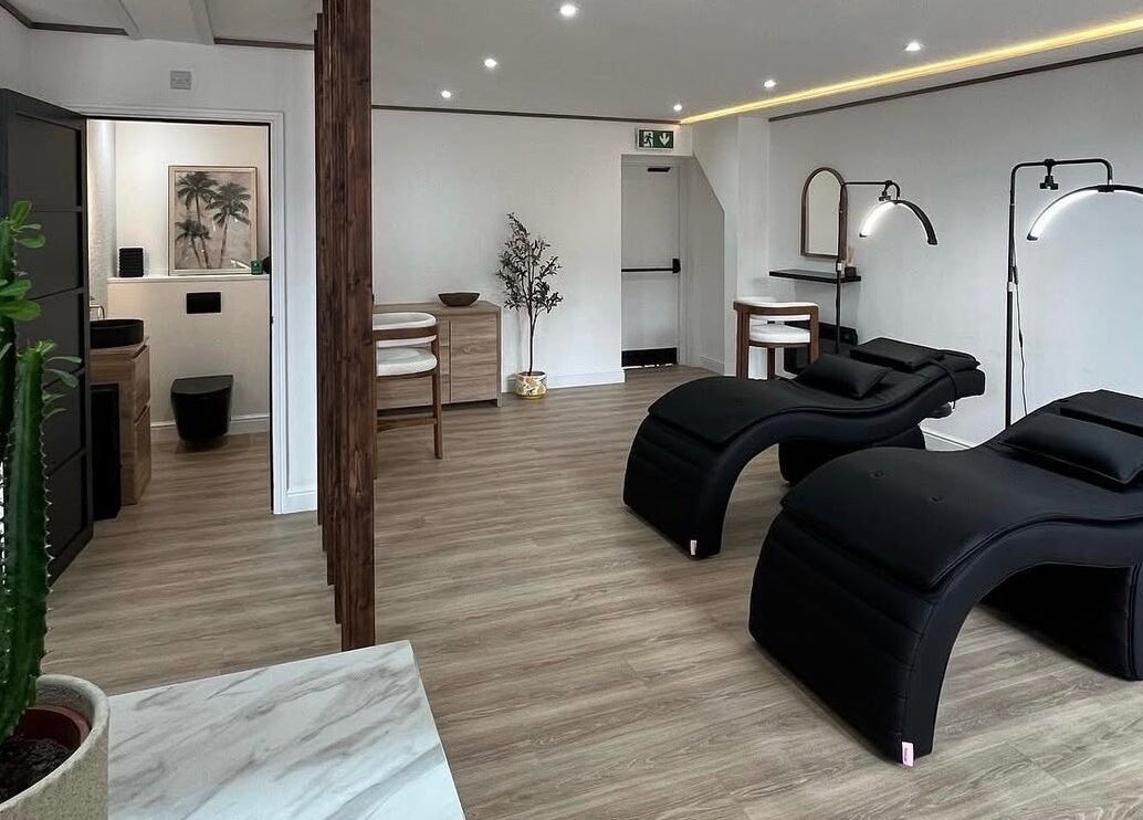 Modern wellness interior at Signature Brows CO, Flint, Wales, GB featuring sleek black loungers and minimalist decor.