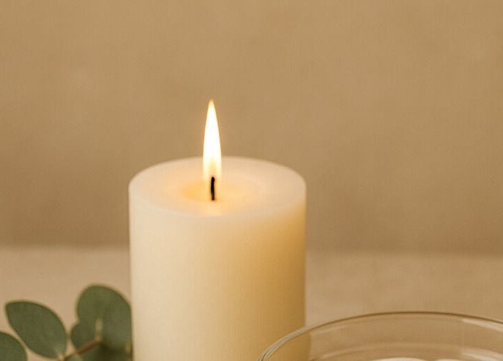 Bougie blanche allumée chez Camille Esthétiques & Soins à Rouyn-noranda, Québec, CA pour une ambiance apaisante.