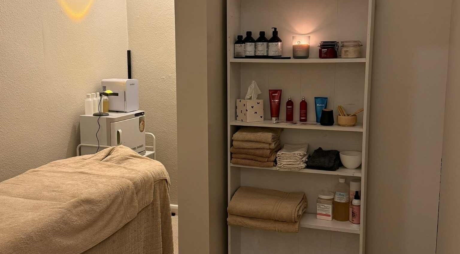 Cozy treatment room at The Beauty Lab, Newark-on-Trent, England, GB. Shelves with products and soft towels.