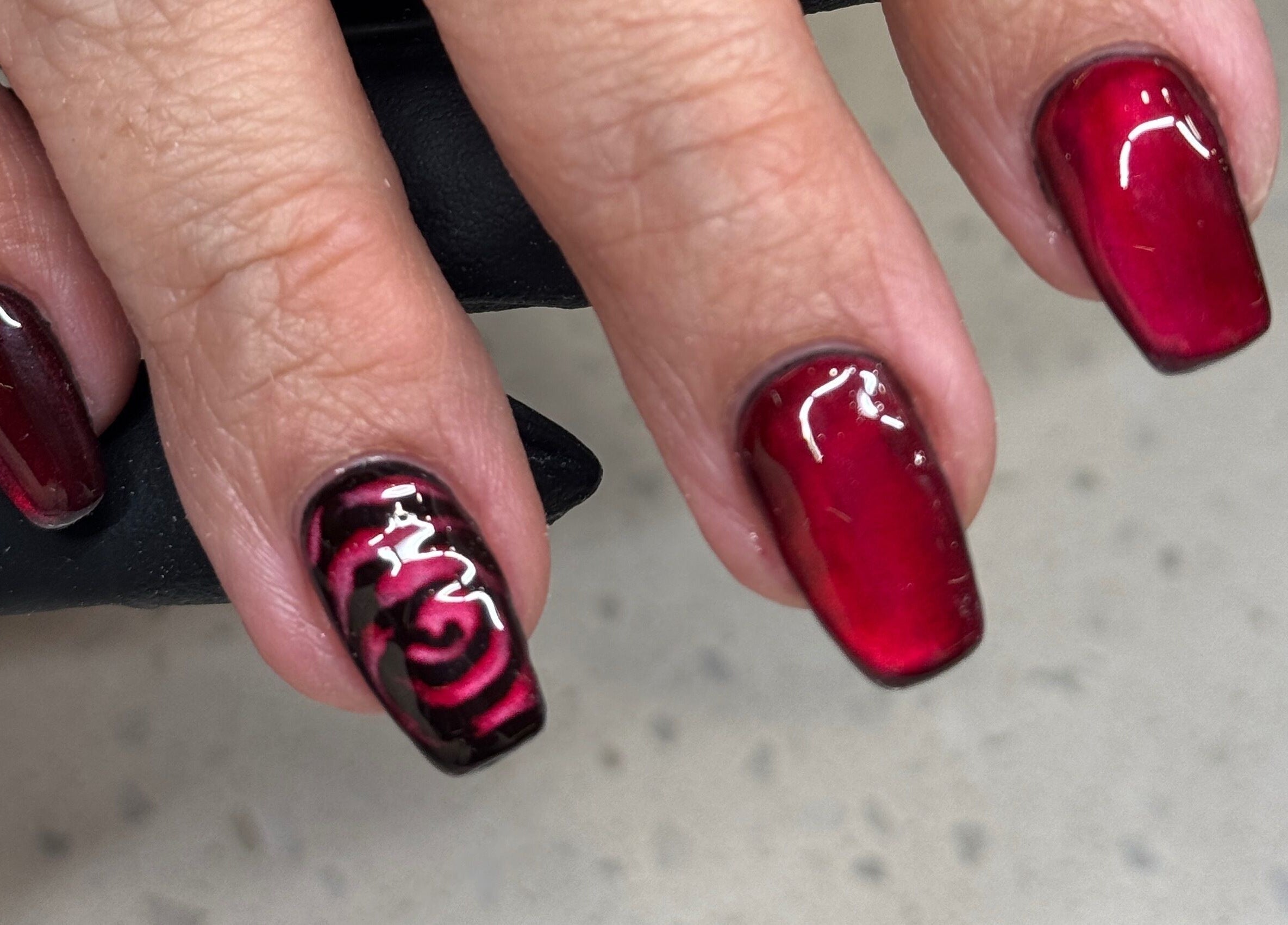 Gorgeous red nail art with floral design at Nails by Orion, Port St. Lucie, Florida, US.
