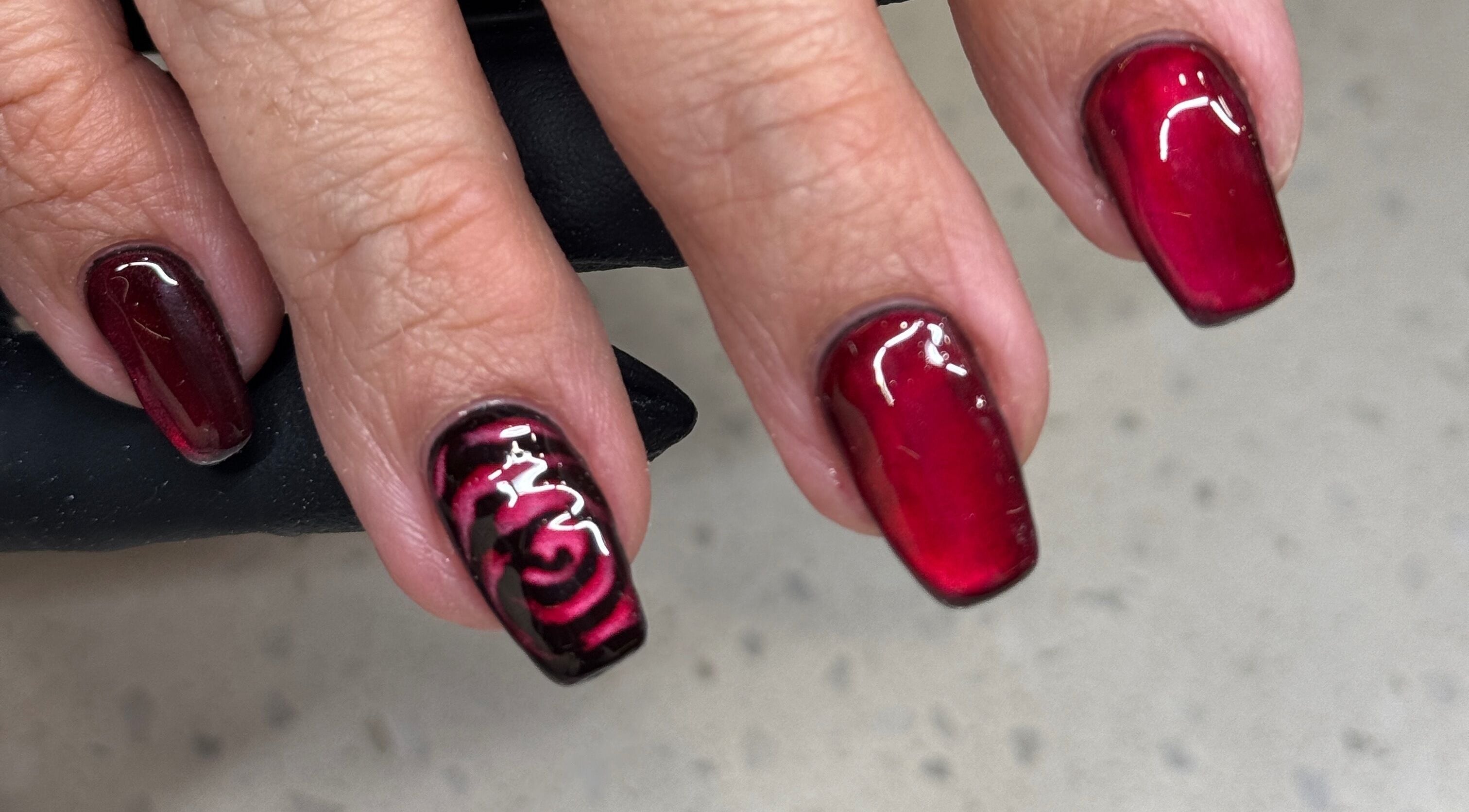 Gorgeous red nail art with floral design at Nails by Orion, Port St. Lucie, Florida, US.