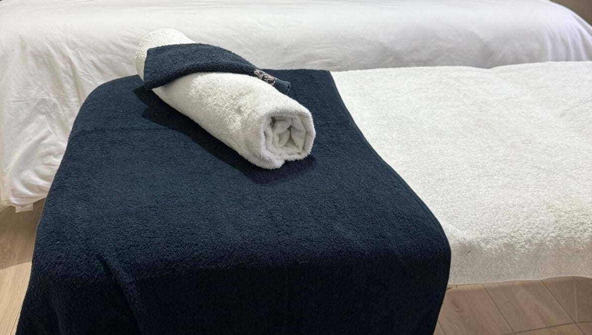 Luxurious massage table setup with soft towels at Lilly Harmony & Sparkle, Sandton, ZA.