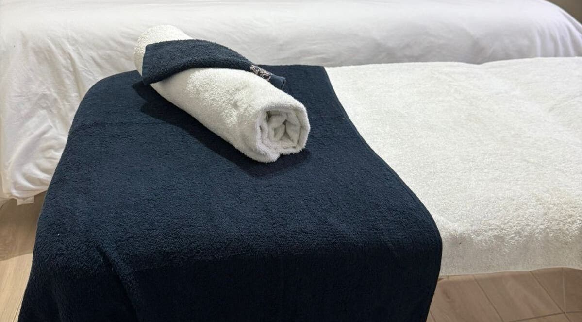 Luxurious massage table setup with soft towels at Lilly Harmony & Sparkle, Sandton, ZA.