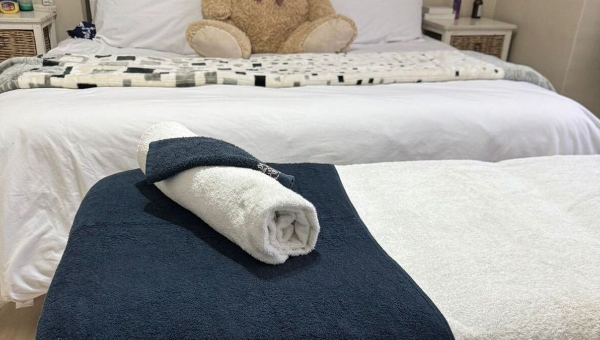 Cozy spa bed setup at Lilly Harmony & Sparkle, Midrand, Gauteng, ZA featuring plush linens and a rolled towel.
