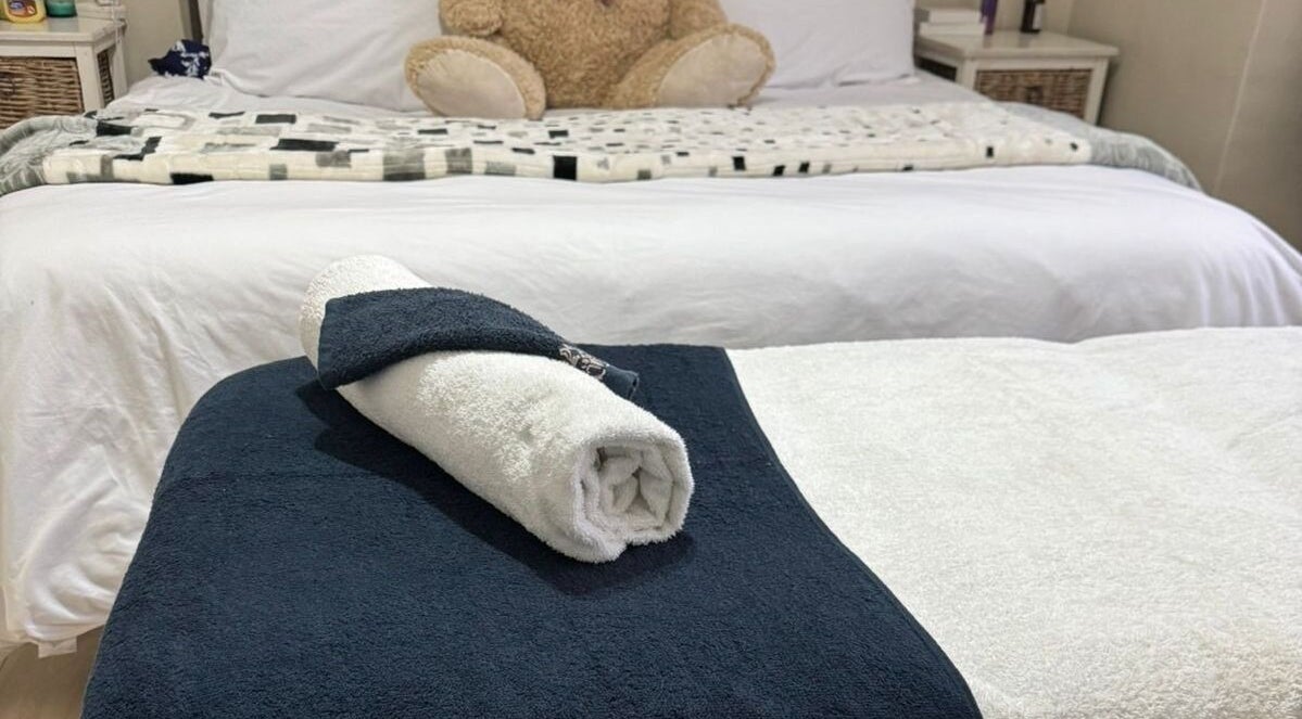 Cozy spa bed setup at Lilly Harmony & Sparkle, Midrand, Gauteng, ZA featuring plush linens and a rolled towel.