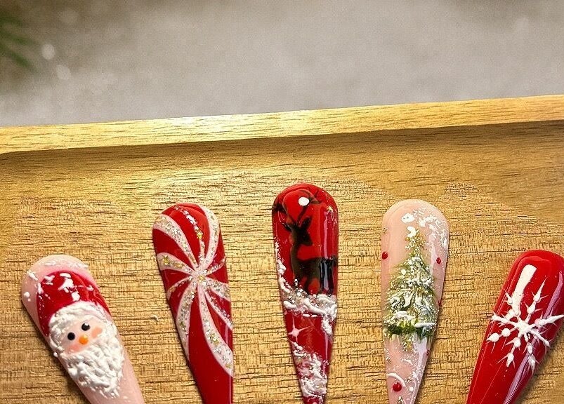 Festive nail art designs at Harmonia Beauty, Prahran, Victoria, AU on a wooden tray.