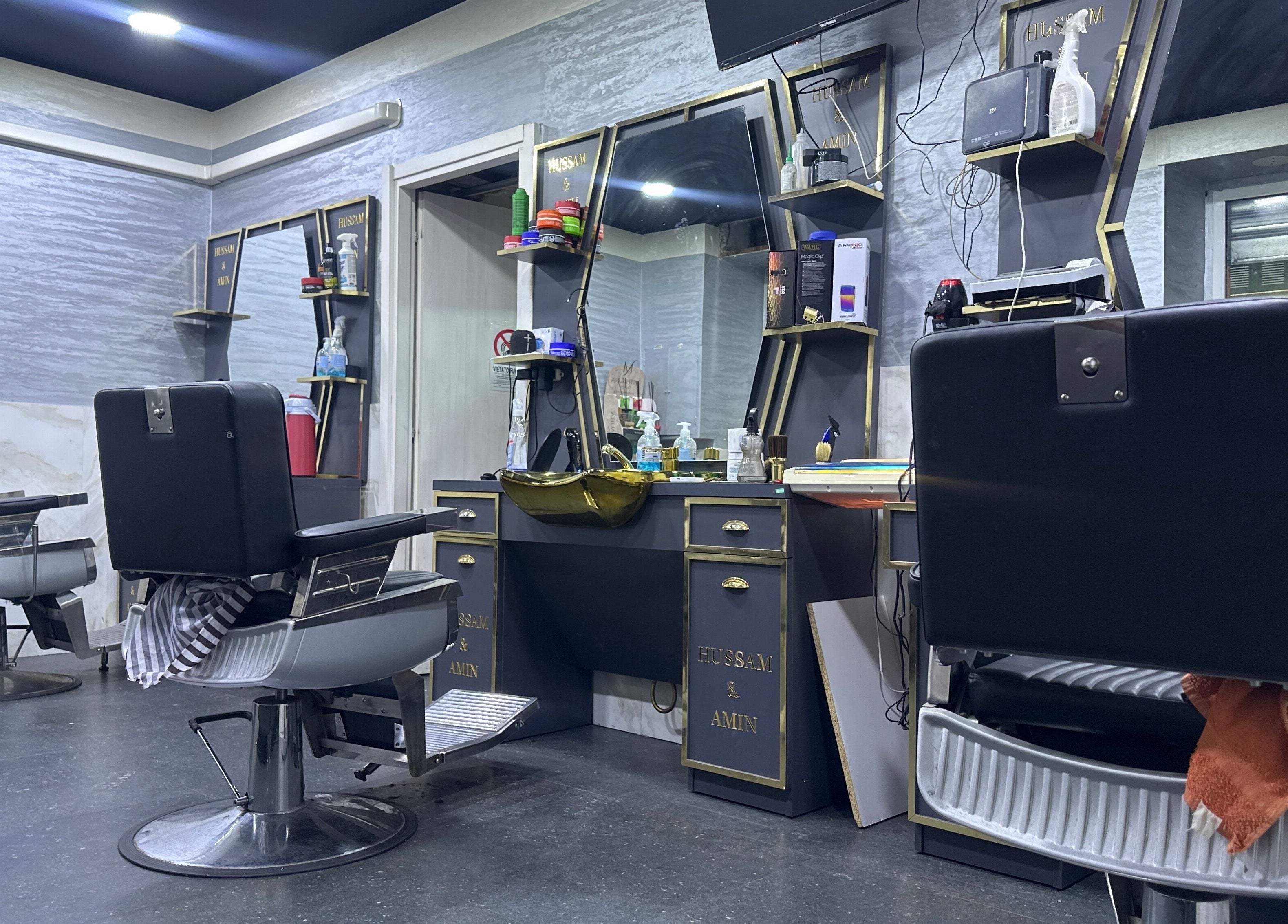 Interno moderno di BARBER HOSSY, Genova, Liguria, IT. Sedie e specchi eleganti per un servizio impeccabile.