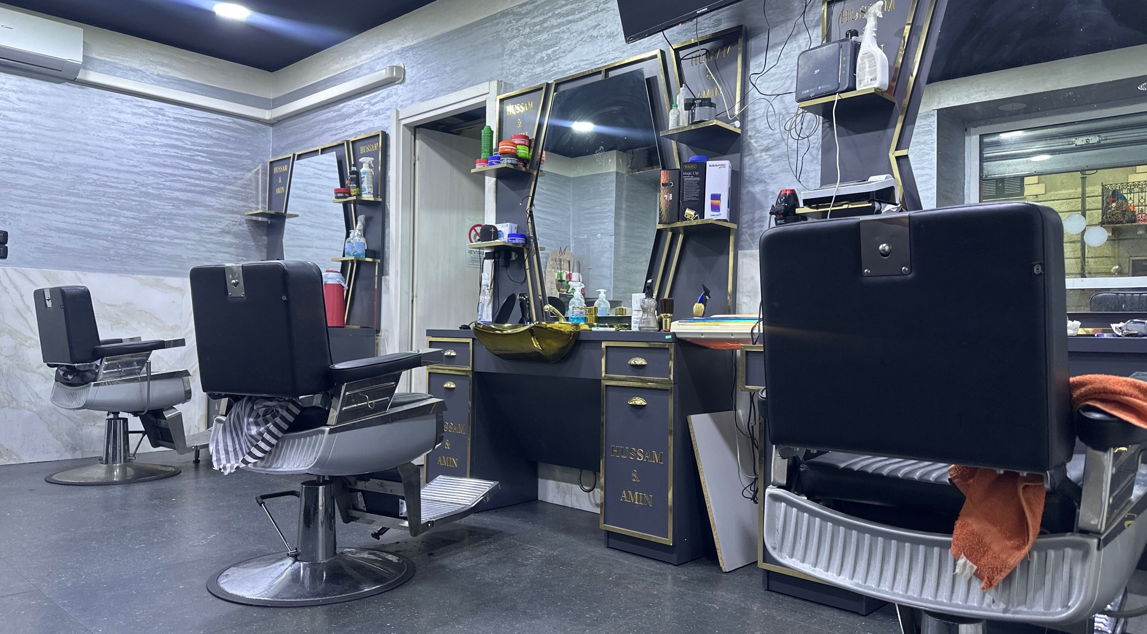 Interno moderno di BARBER HOSSY, Genova, Liguria, IT. Sedie e specchi eleganti per un servizio impeccabile.