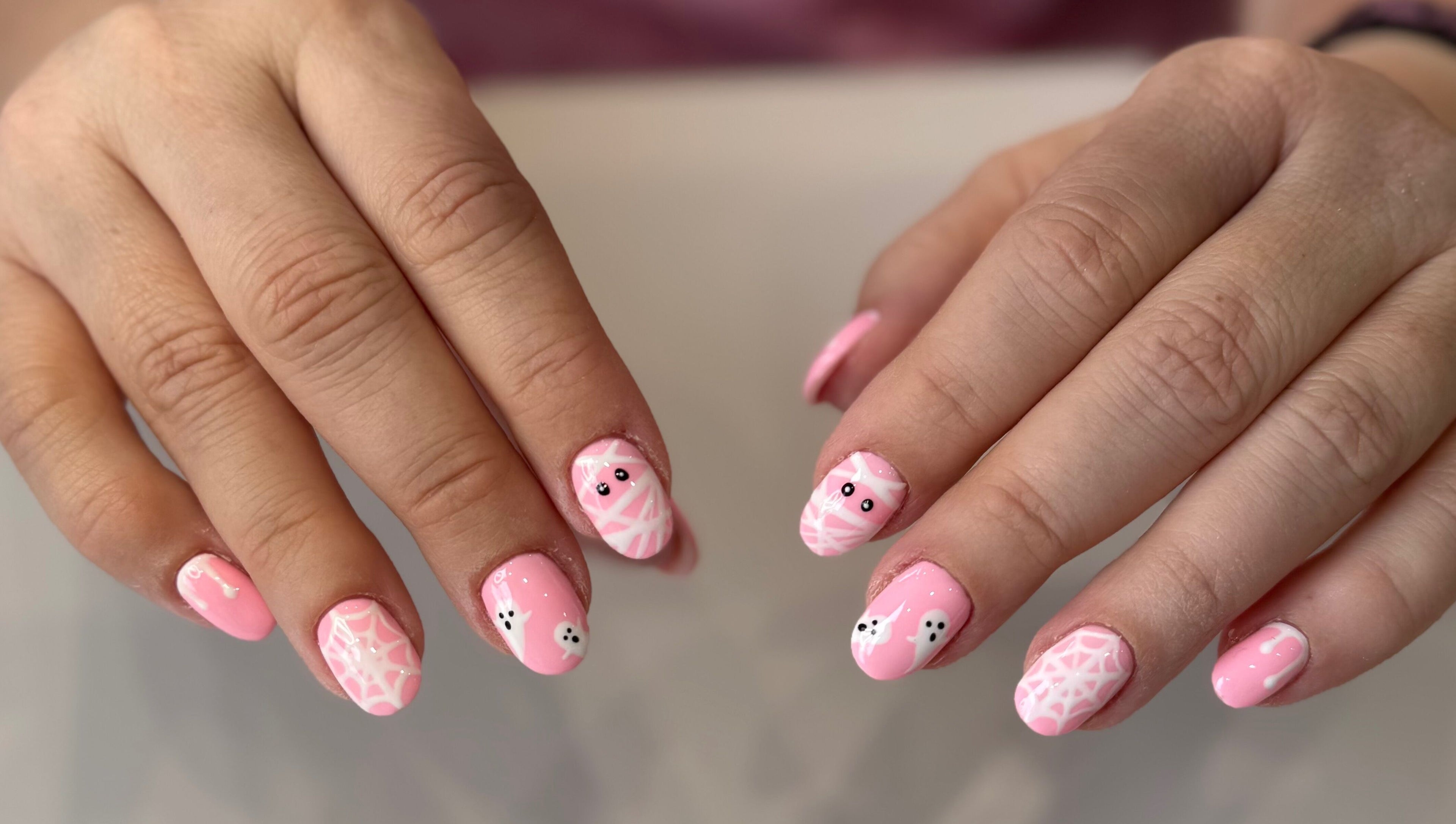 Pink Halloween nail art at Zara Nails, Kingston Upon Thames, England, GB, showcasing cute ghost designs.