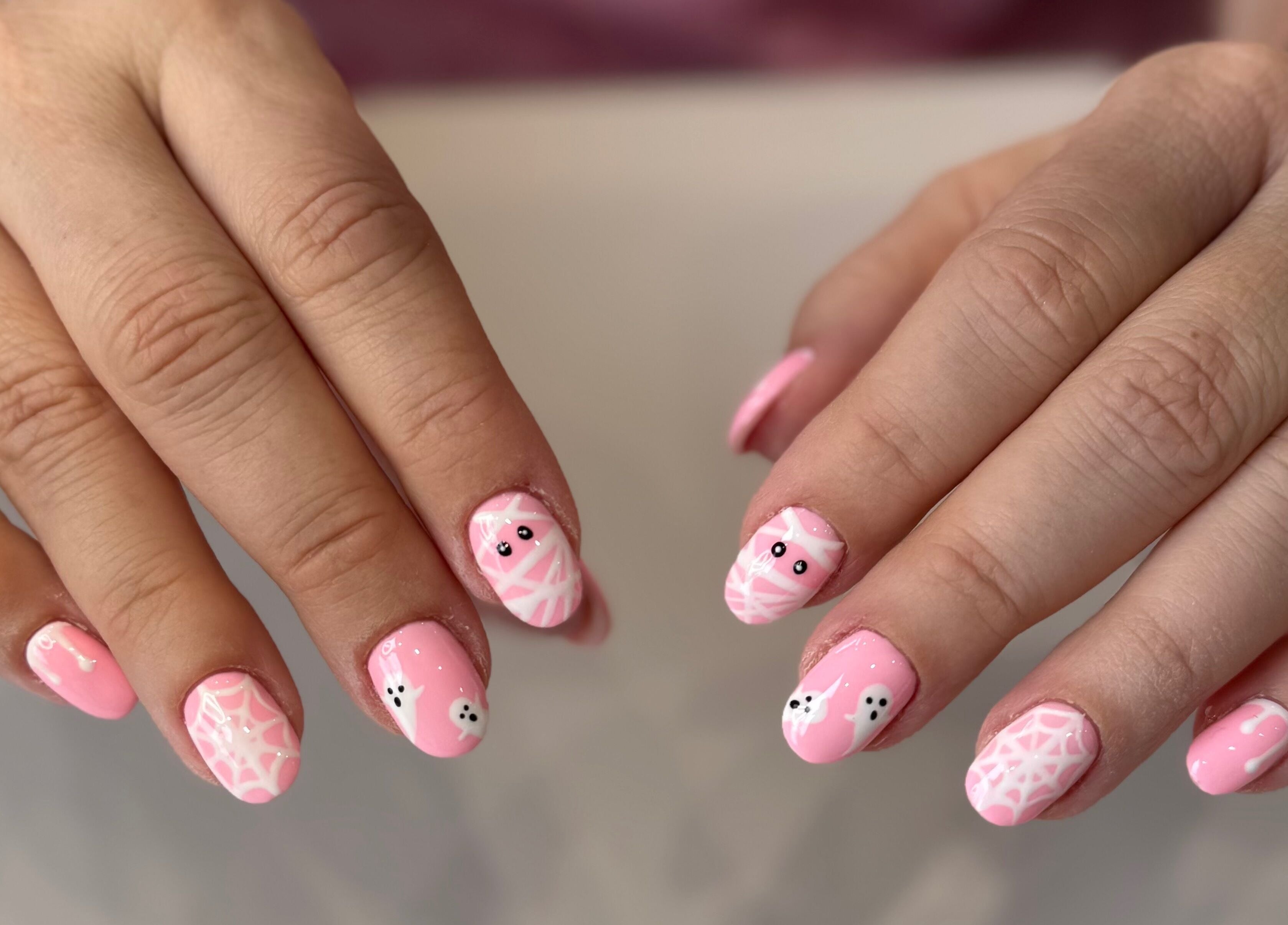 Pink Halloween nail art at Zara Nails, Kingston Upon Thames, England, GB, showcasing cute ghost designs.