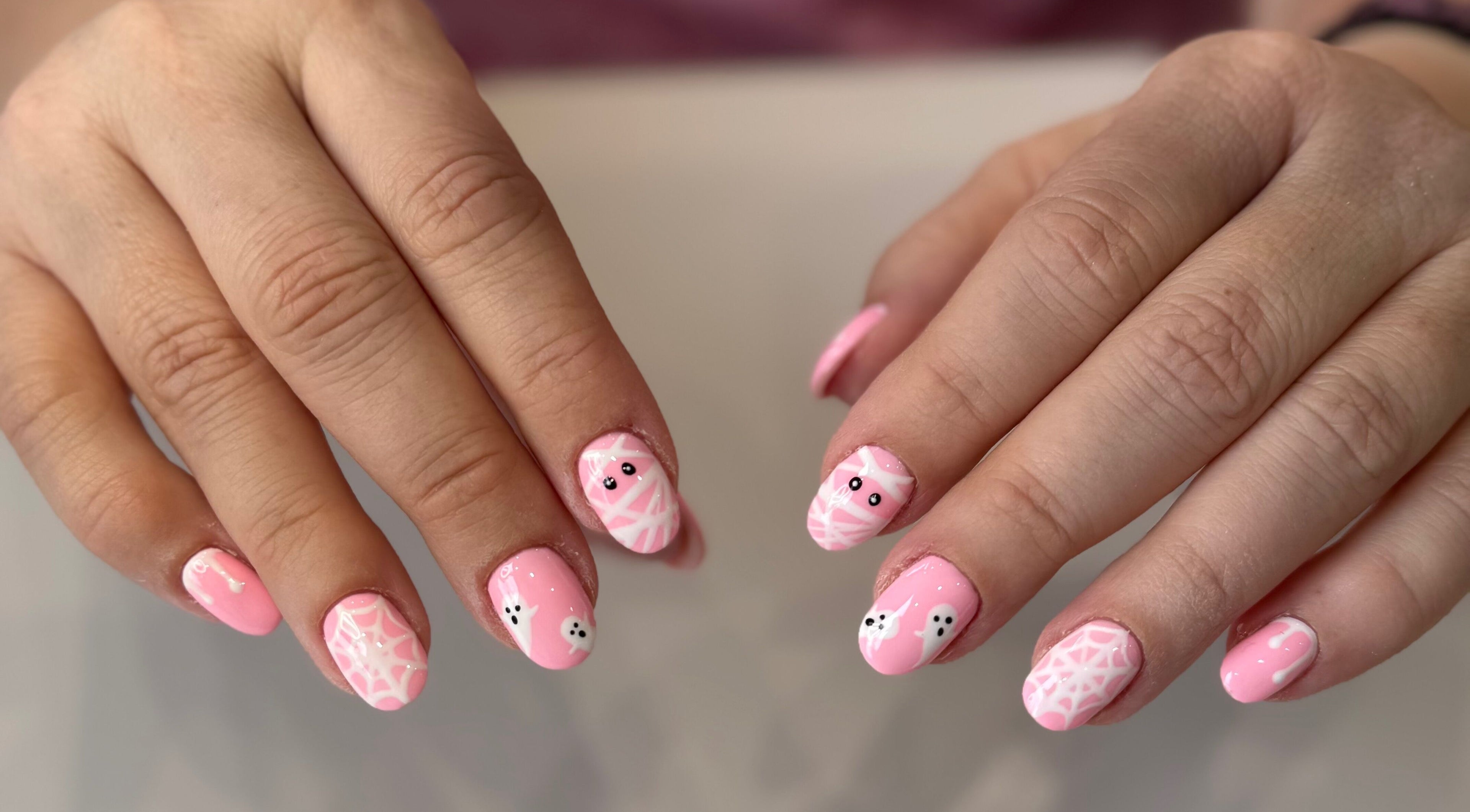 Pink Halloween nail art at Zara Nails, Kingston Upon Thames, England, GB, showcasing cute ghost designs.