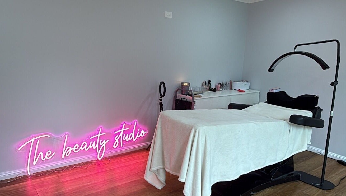Treatment room at The Beauty Studio, Wilberforce, New South Wales, AU with neon sign and treatment bed.