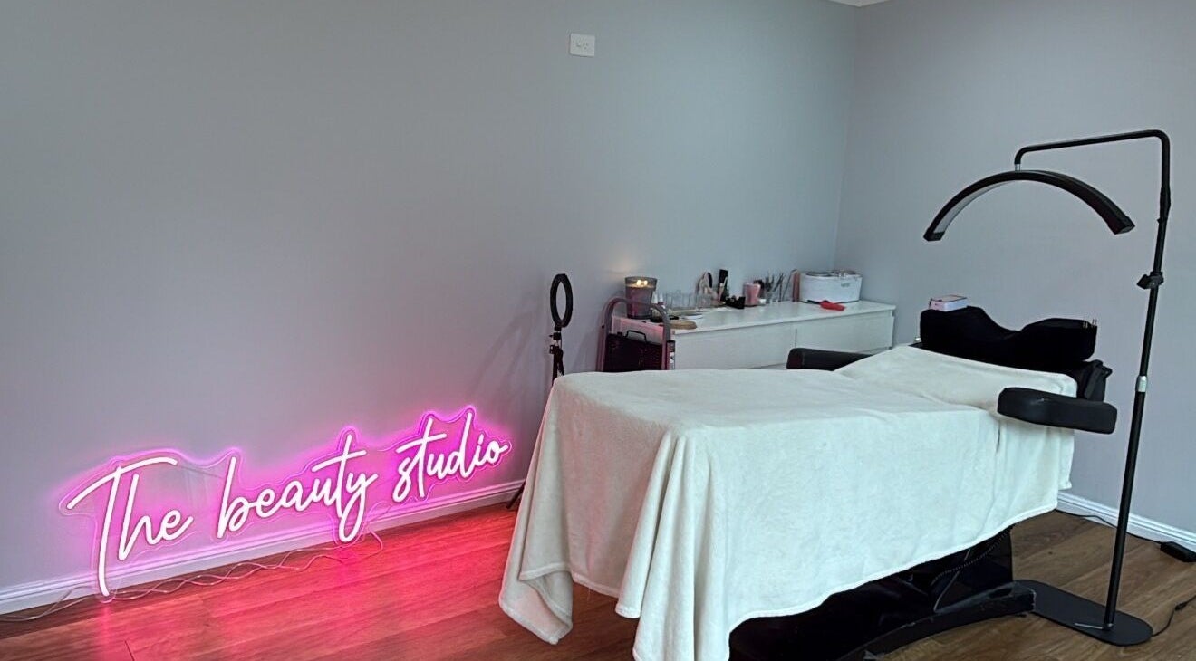 Treatment room at The Beauty Studio, Wilberforce, New South Wales, AU with neon sign and treatment bed.
