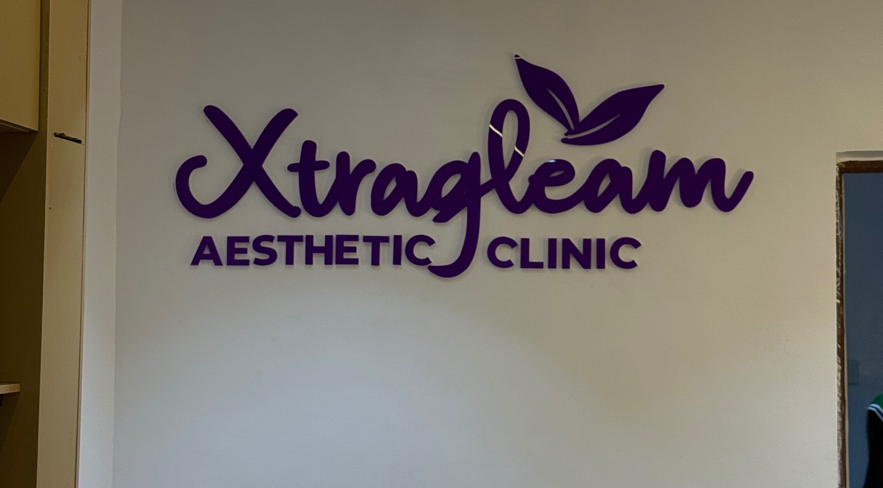 XTRAGLEAM AESTHETIC CLINIC (LAGOS) wall signage in Agege, Lagos, NG featuring bold purple letters.