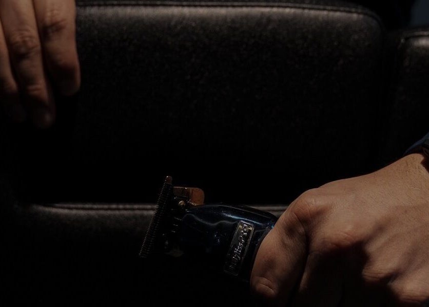 Close-up of a barber's hands with clippers at District Barber Society, Naucalpan De Juárez, Estado De México, MX.