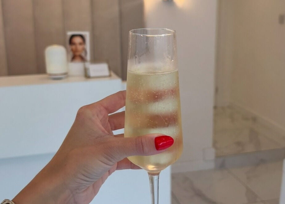 Close-up of a hand holding a champagne glass at With Love in Highcliffe, England, GB.