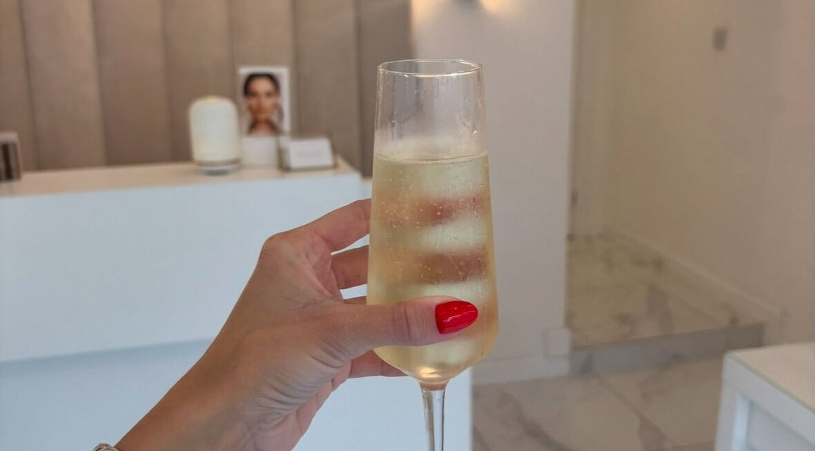 Close-up of a hand holding a champagne glass at With Love in Highcliffe, England, GB.