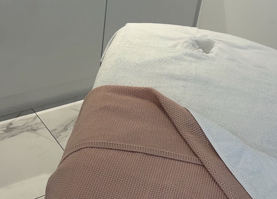 Sophisticated massage table at With Love, Highcliffe, England, GB with plush towels enhancing relaxation.