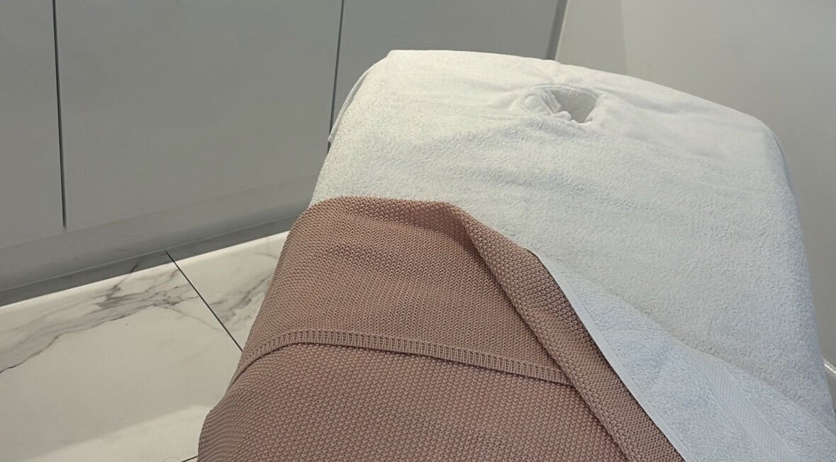 Sophisticated massage table at With Love, Highcliffe, England, GB with plush towels enhancing relaxation.