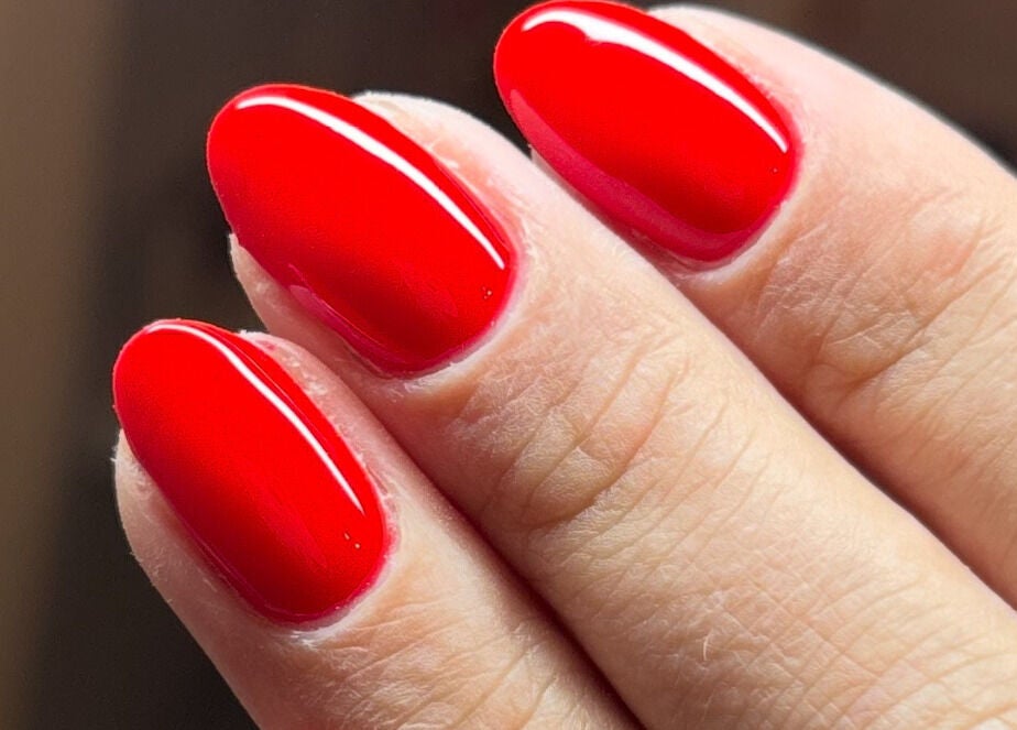 Glossy red manicured nails at With Love, Highcliffe, England, GB showcasing vibrant beauty.