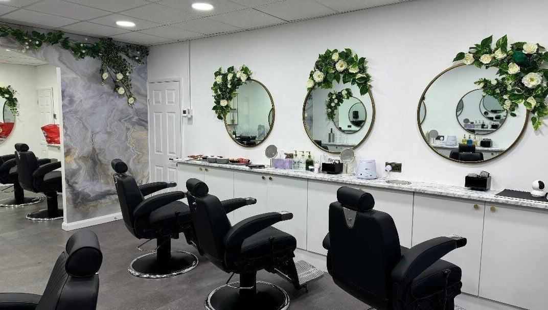 Elegant salon interior at Olympus Hair in Chester, England, GB with stylish chairs and floral decor.