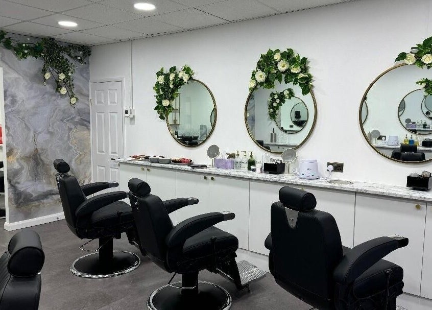 Elegant salon interior at Olympus Hair in Chester, England, GB with stylish chairs and floral decor.