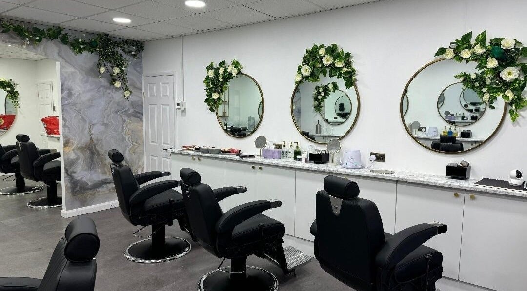 Elegant salon interior at Olympus Hair in Chester, England, GB with stylish chairs and floral decor.