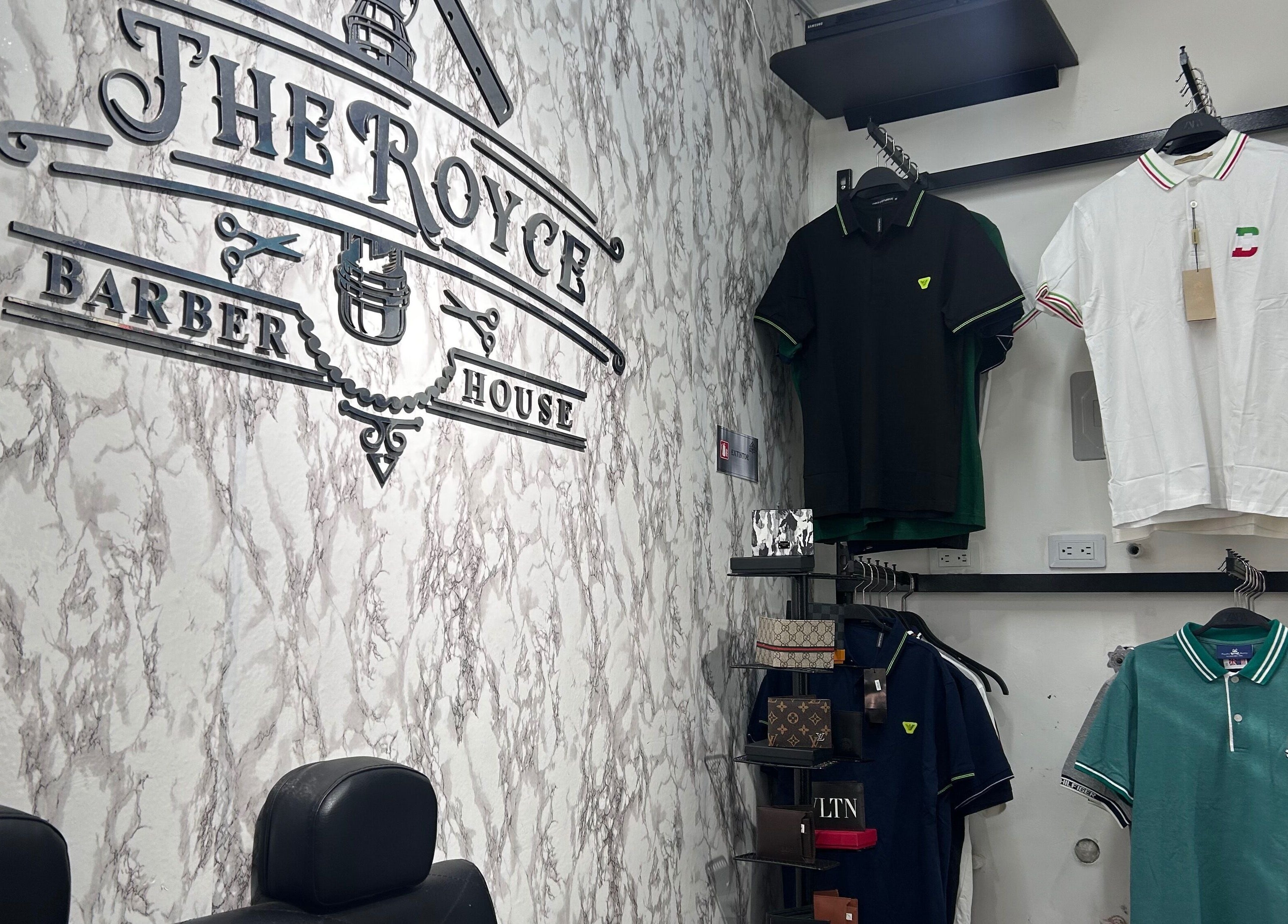 Interior de The Royce Barber House en Bogotá, Bogotá, CO, con prendas y decoración elegante.