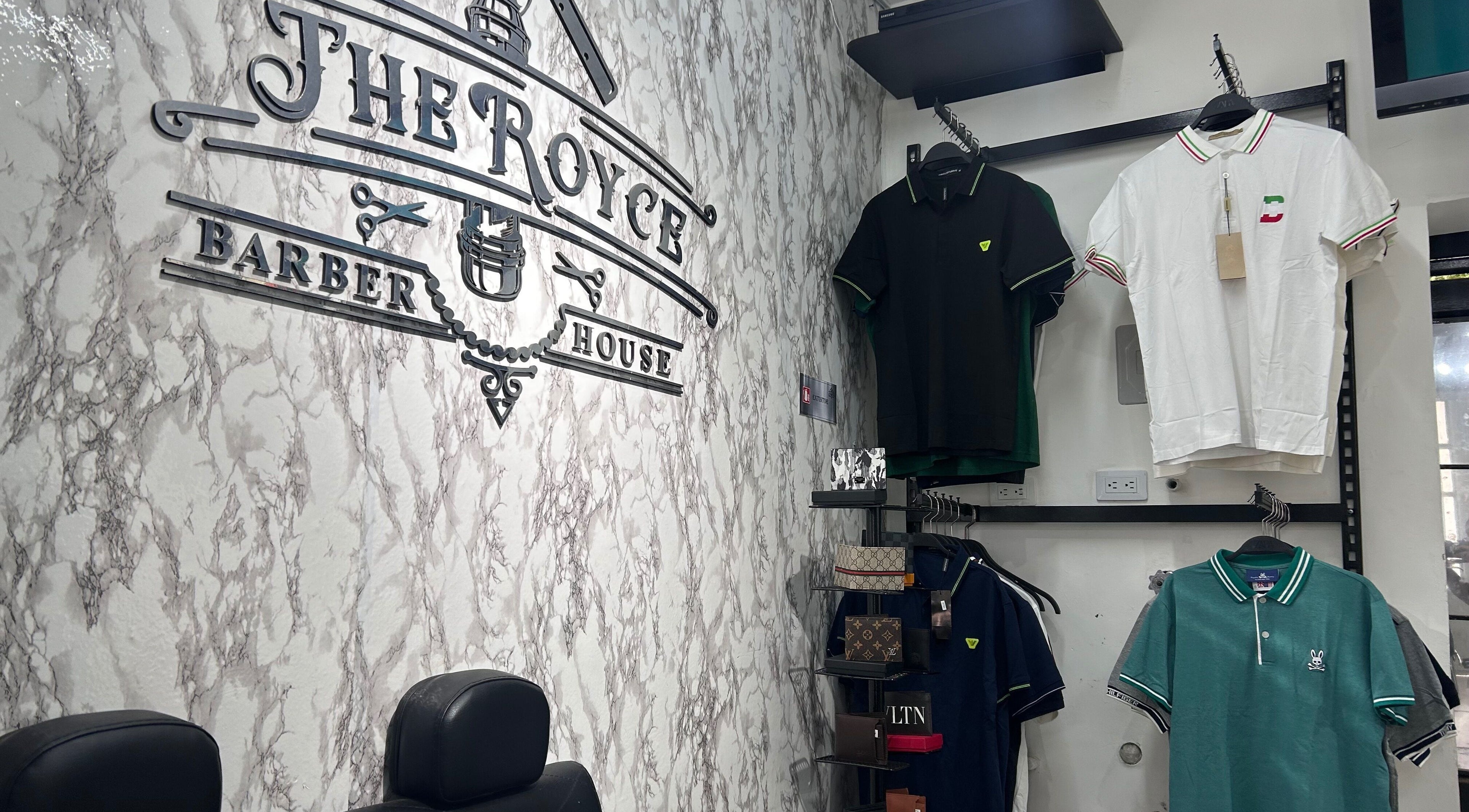 Interior de The Royce Barber House en Bogotá, Bogotá, CO, con prendas y decoración elegante.