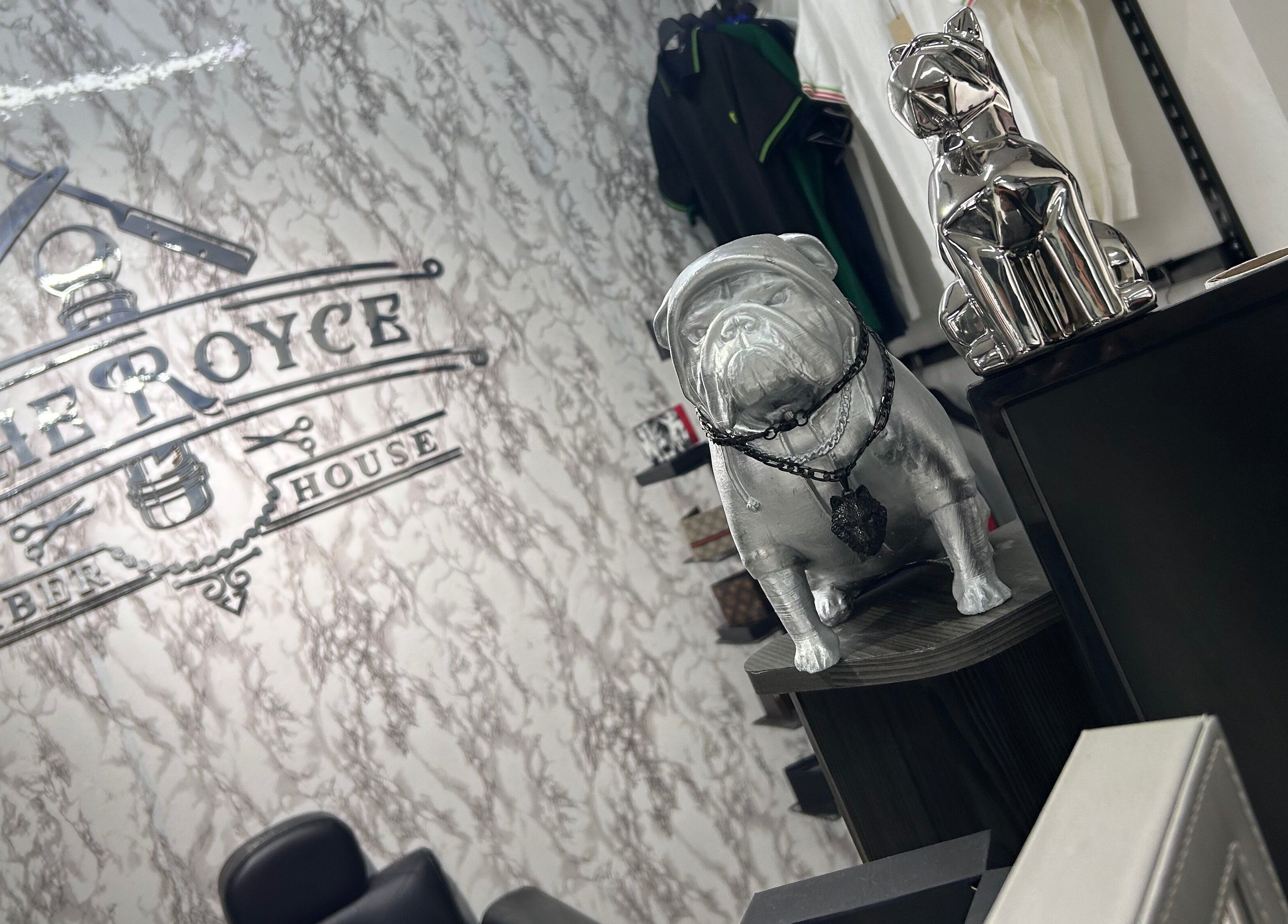 Decoración interior de The Royce Barber House en Bogotá, Bogotá, CO con estatuas y logo distintivo.