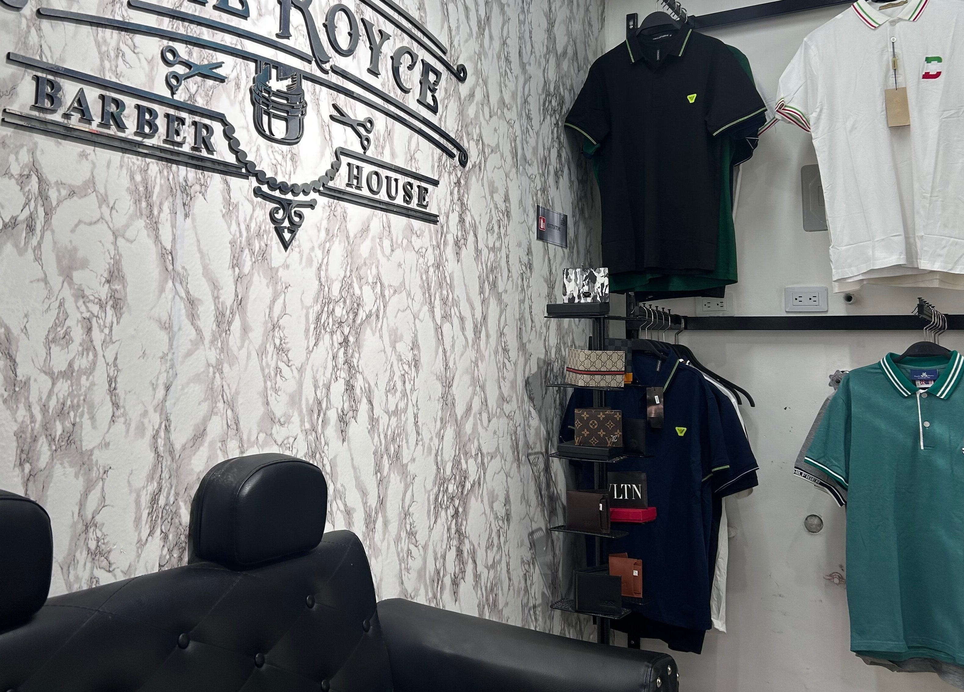 Interior de The Royce Barber House en Bogotá, Bogotá, CO con camisetas y sillón moderno.