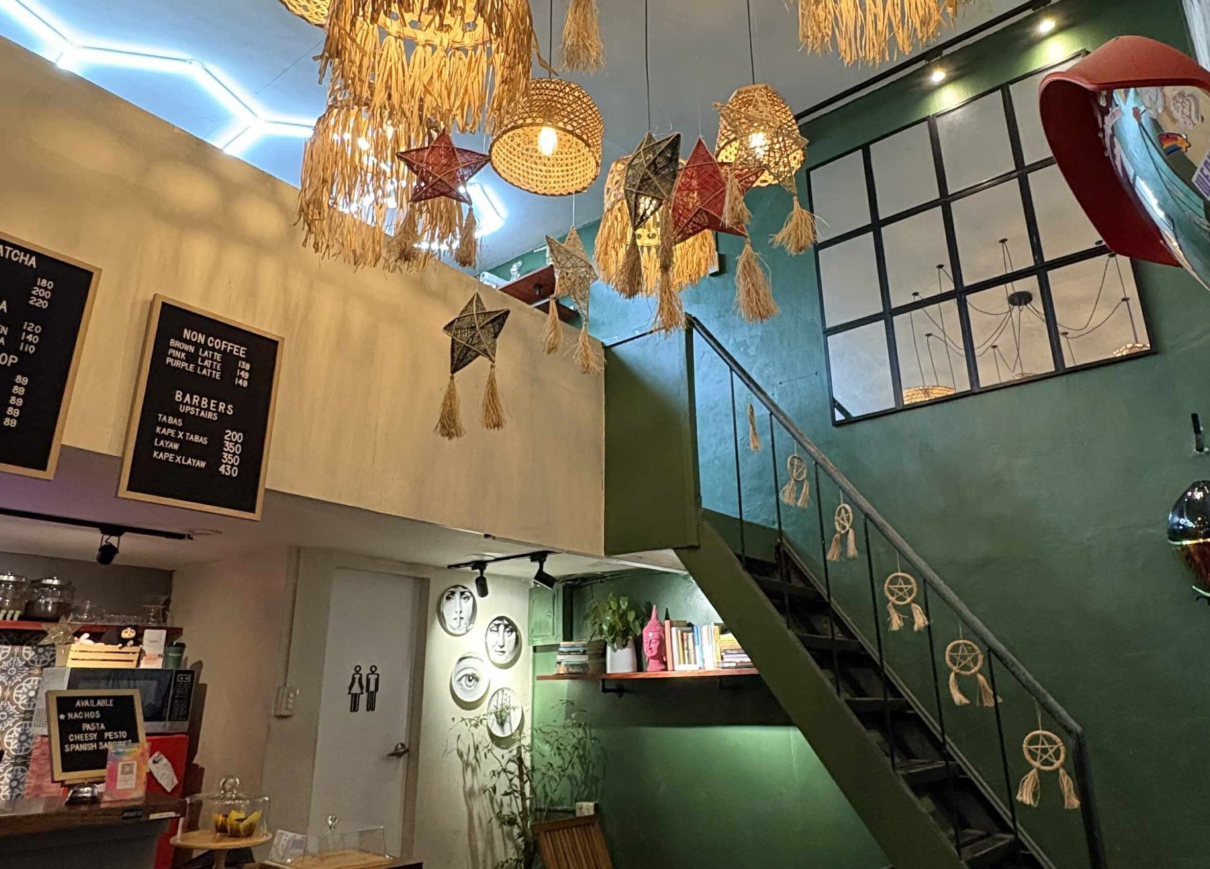 Rustic interior of The Eastside Cafe & Barbers in Marikina City with menu boards and unique star decorations.