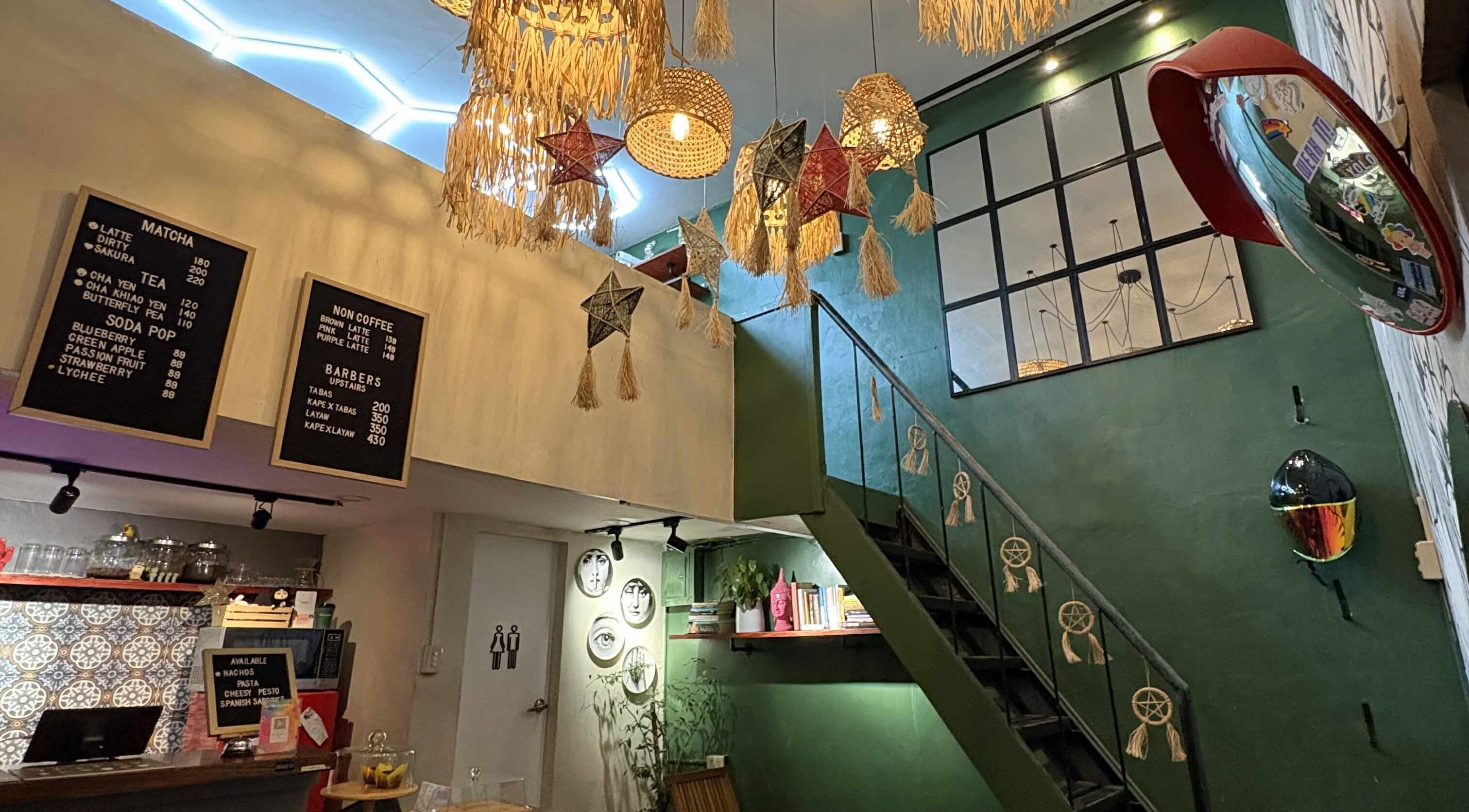 Rustic interior of The Eastside Cafe & Barbers in Marikina City with menu boards and unique star decorations.