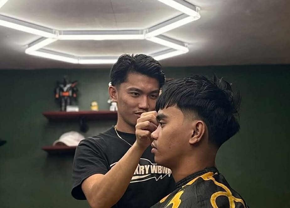 Stylist giving haircut at The Eastside Cafe & Barbers, Marikina City, Metro Manila, PH.