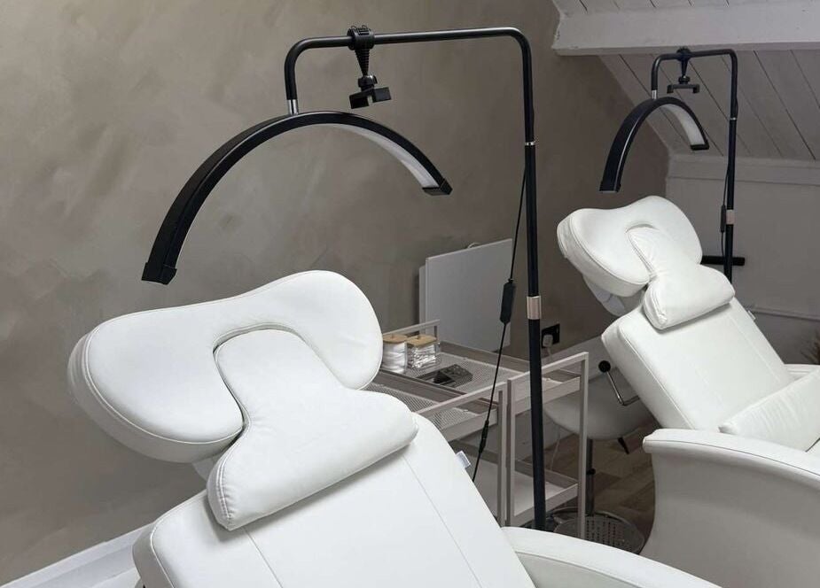 Modern white massage chairs at Lash & Brow Expert in London, England, GB, offering ultimate relaxation.