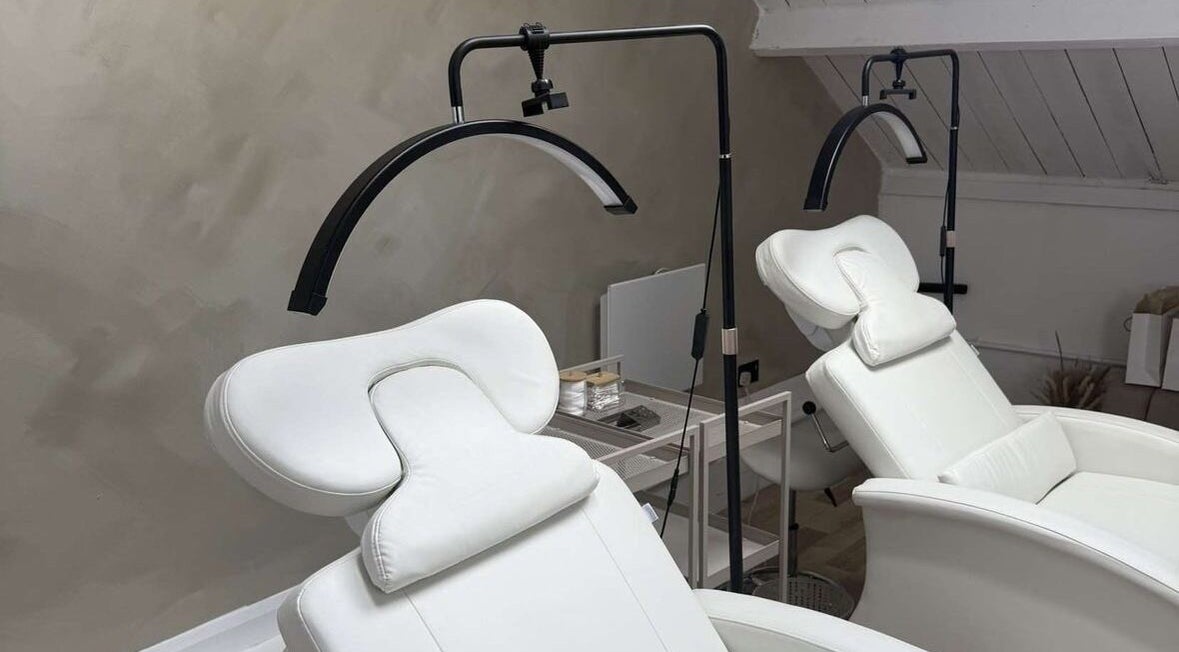 Modern white massage chairs at Lash & Brow Expert in London, England, GB, offering ultimate relaxation.