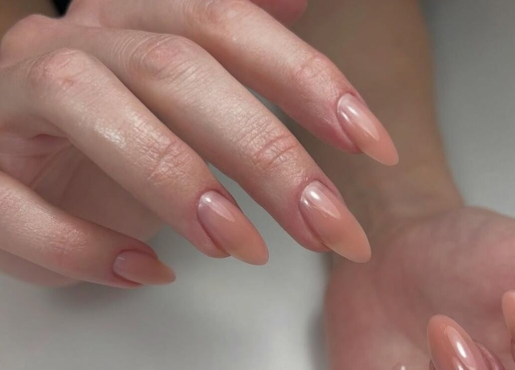 Close-up of an elegant manicure at Sole Beaut& Nail in Toronto, Ontario, CA showing glossy, nude nails.