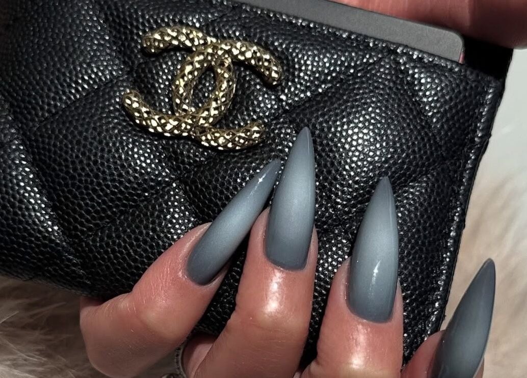 Elegant grey nails at Sole Beaut& Nail in Toronto, Ontario, CA, beside a luxury leather accessory.