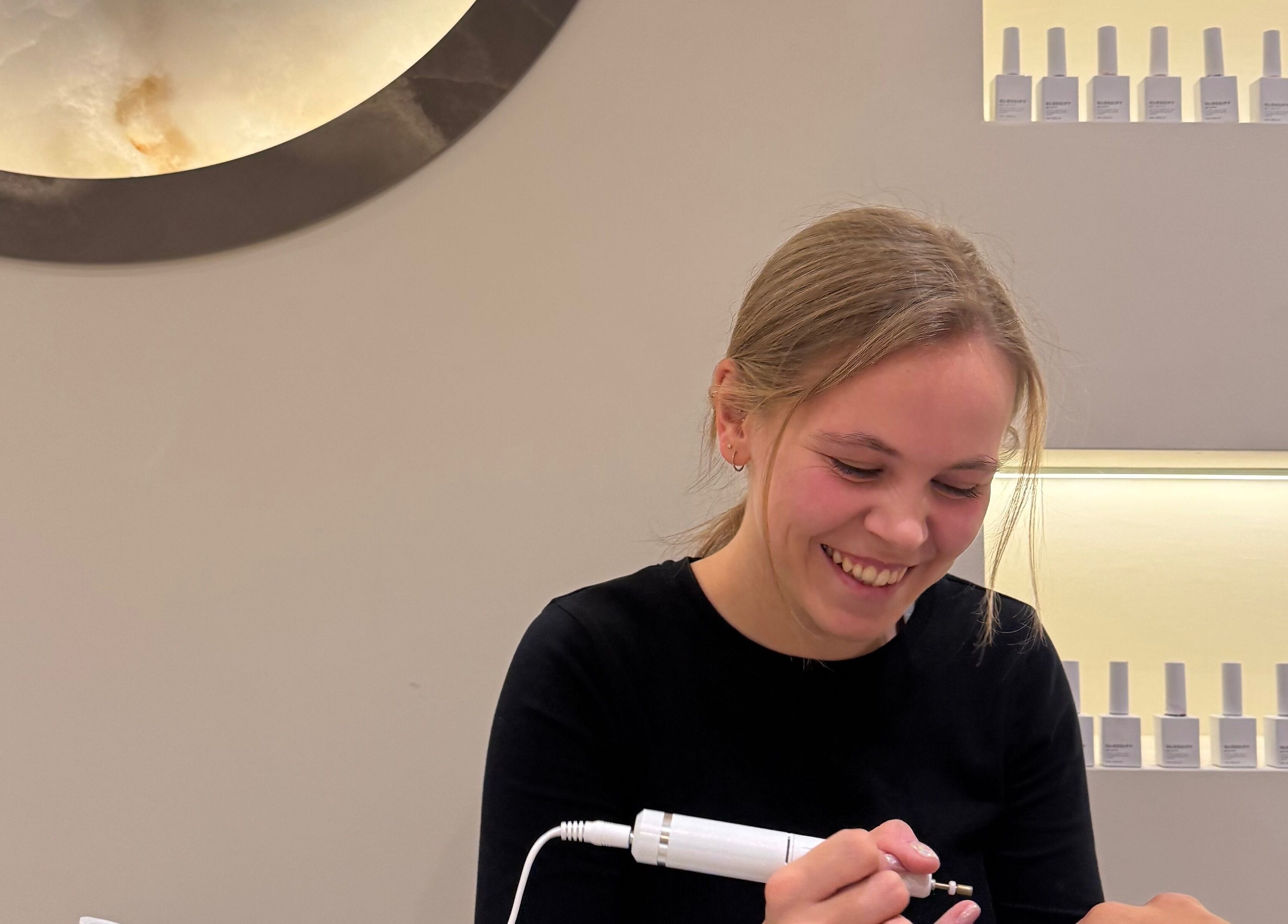 A joyful nail technician at Radiant Nails, Clayton-le-Woods, England, applying a manicure.
