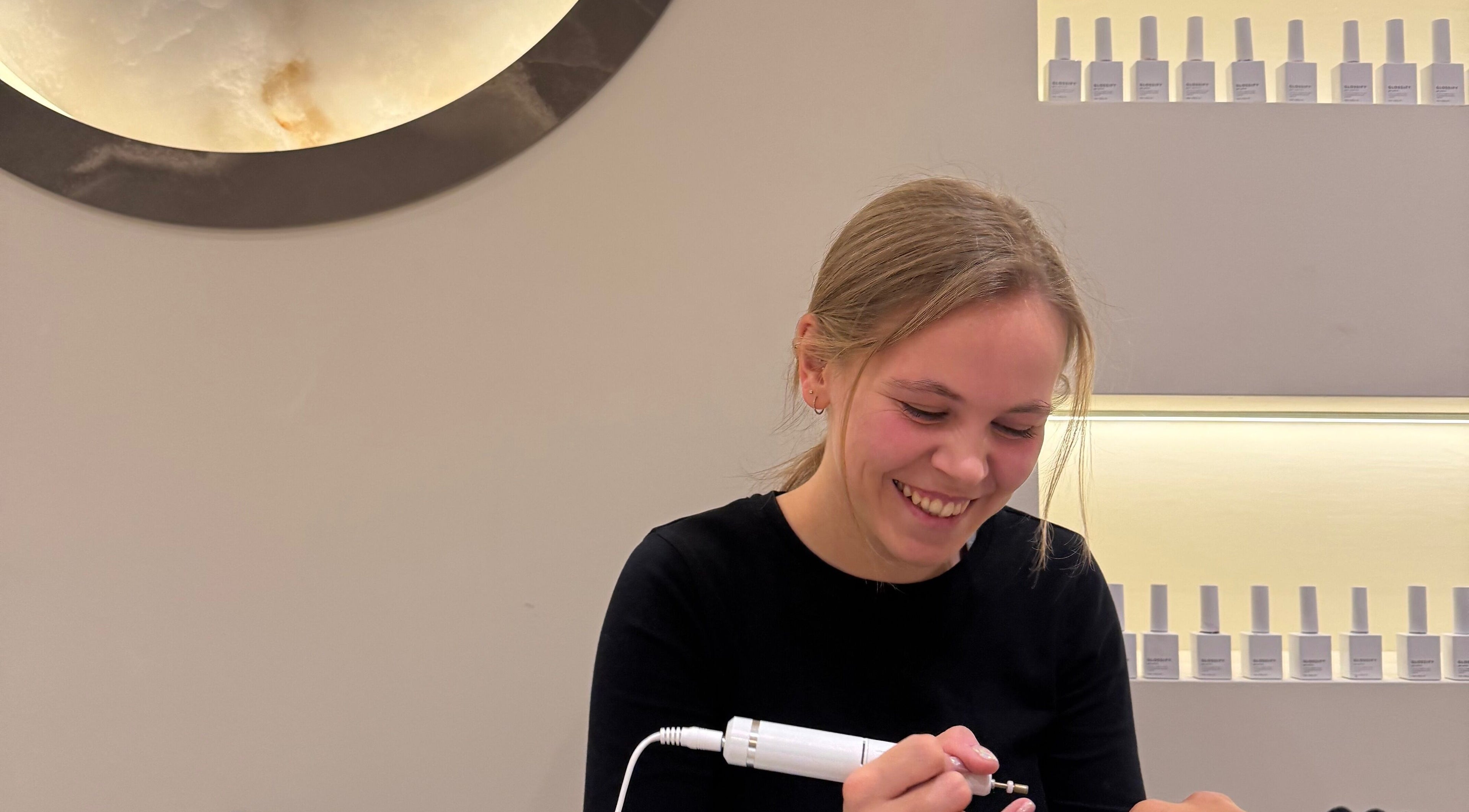 A joyful nail technician at Radiant Nails, Clayton-le-Woods, England, applying a manicure.