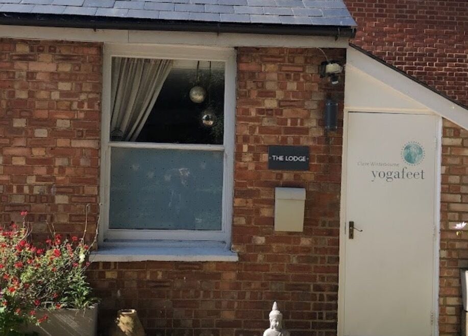Front view of Jess Clark Yoga Massage venue in Hitchin, England, GB with vibrant flowers and a white entrance.