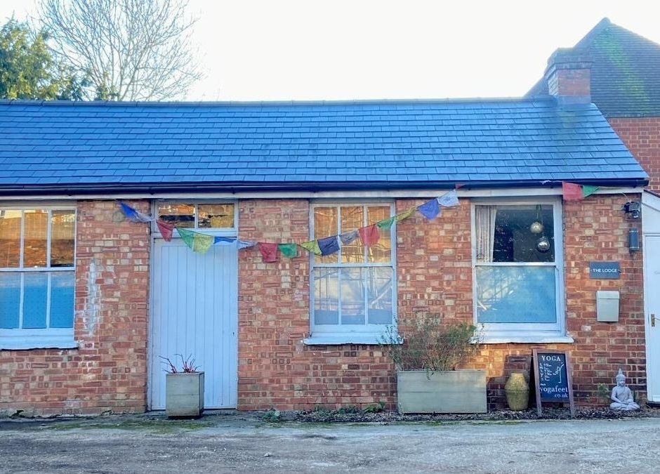 Charming brick exterior of Jess Clark Yoga Massage, Hitchin, England, GB, adorned with colorful bunting.