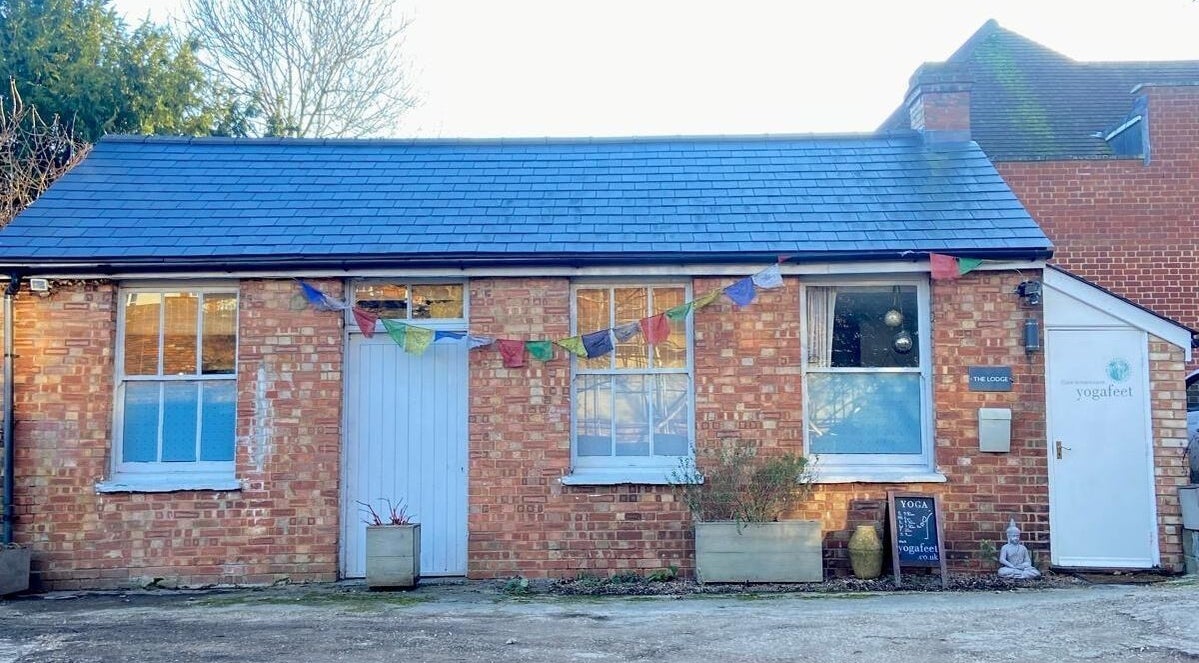 Charming brick exterior of Jess Clark Yoga Massage, Hitchin, England, GB, adorned with colorful bunting.