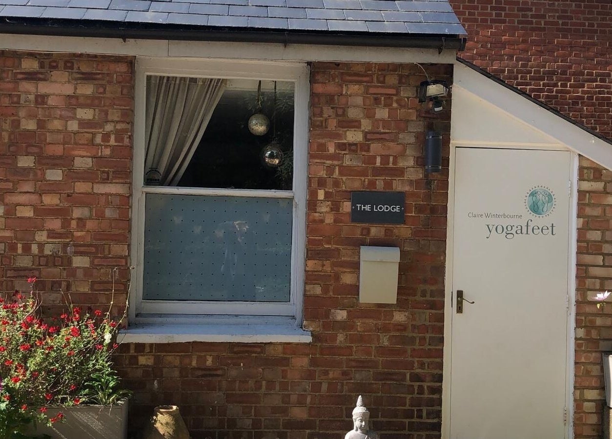 Entrance of Jess Clark Yoga Massage at The Lodge, Hitchin, England, GB, adorned with colorful flowers.